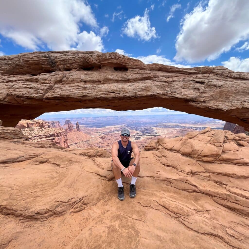 Dylan Love sitting on a scenic rock