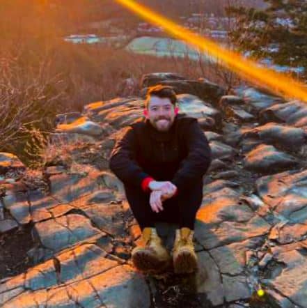 Matthew Dolan sitting on rock during sunset