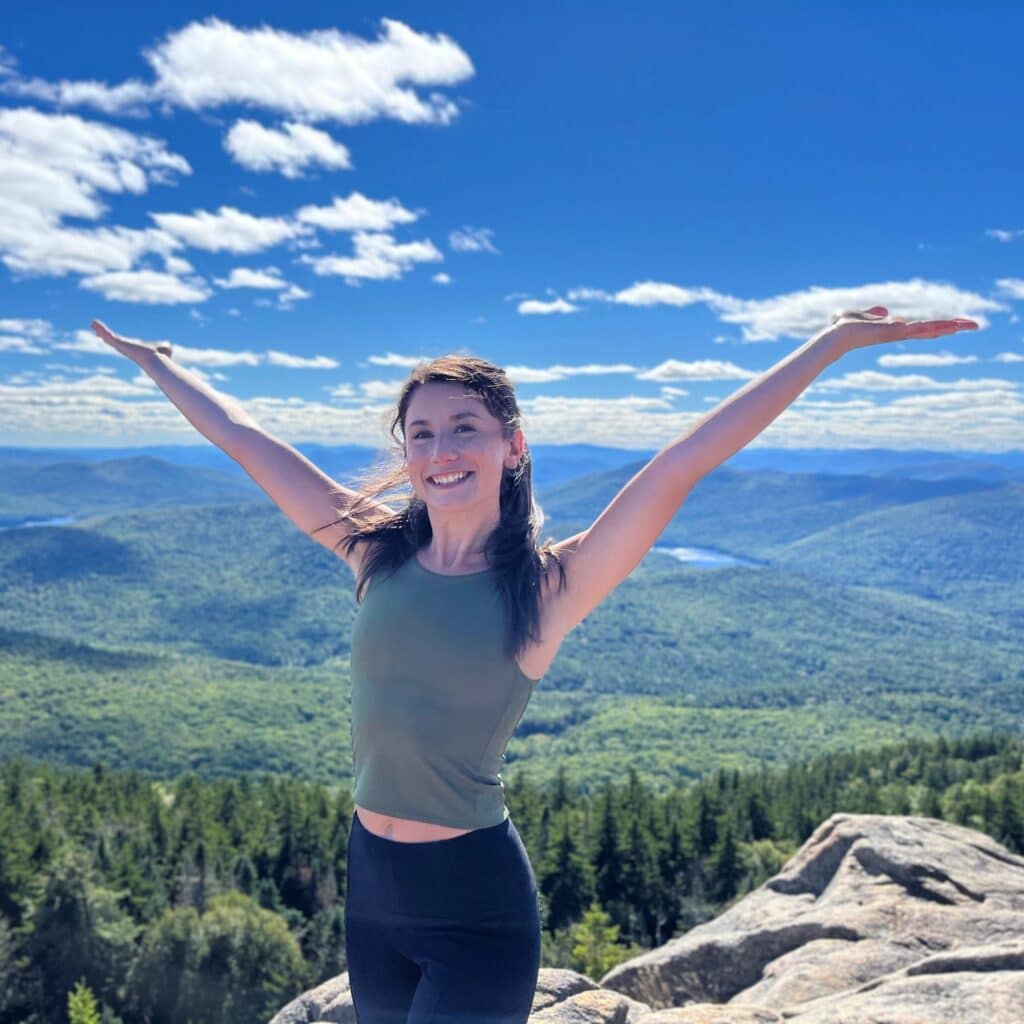 Nicole Pia on mountain top overlooking a forest