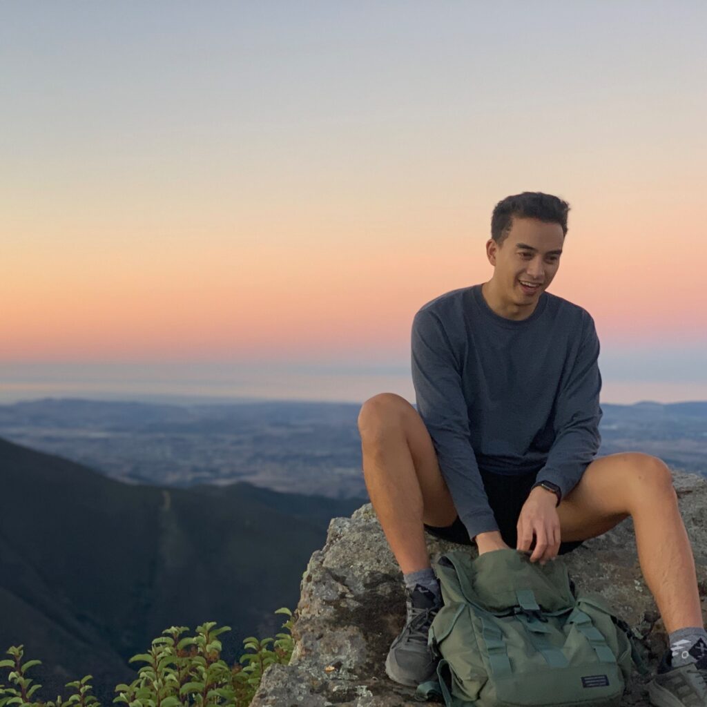 Kyle Luna sitting on a rock